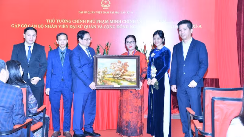 Thủ tướng Phạm Minh Chính tặng quà lưu niệm cho cộng đồng người Việt Nam tại Malaysia.(Ảnh: THANH GIANG)