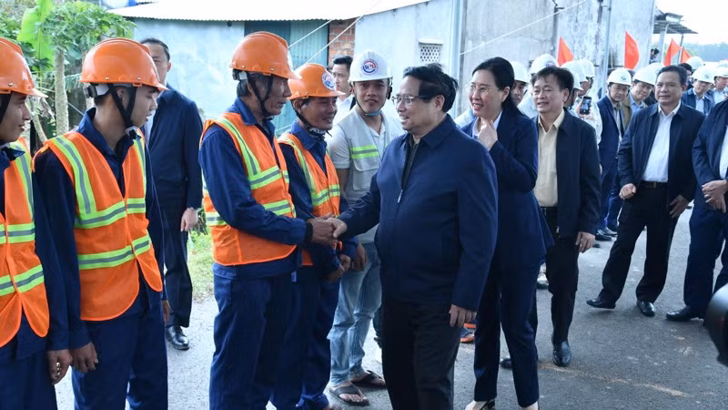 Thủ tướng Phạm Minh Chính thăm hỏi, động viên các kỹ sư, công nhân đang thi công tuyến đường. (Ảnh: THANH GIANG)