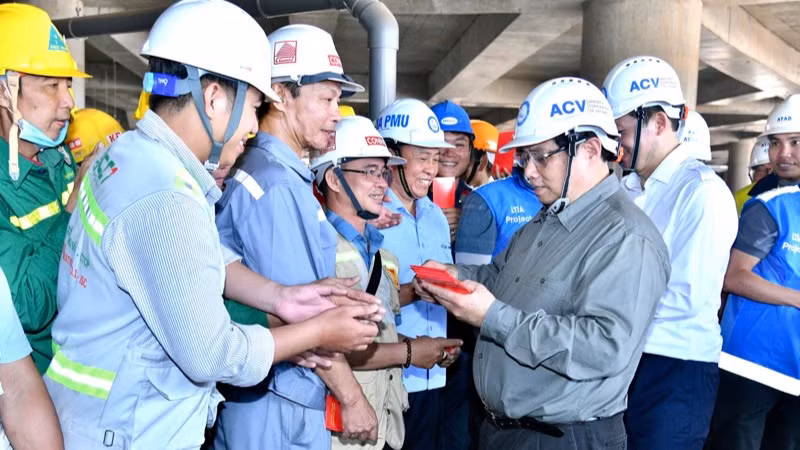 Thủ tướng Phạm Minh Chính mừng tuổi Xuân mới cho các kỹ sư, công nhân tại công trường nhà ga chính Sân bay Long Thành. (Ảnh: THANH GIANG)