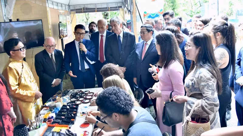 Thủ tướng Phạm Minh Chính và các đại biểu nghe giới thiệu về cách làm tranh sơn mài. (Ảnh: Thanh Giang)