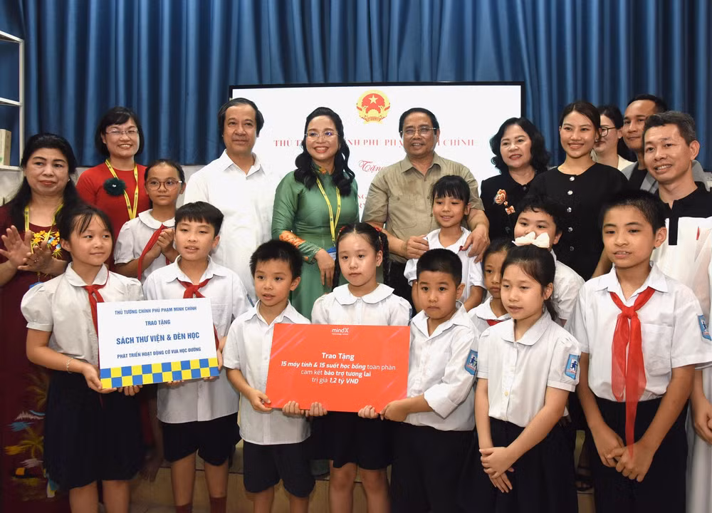Thủ tướng Phạm Minh Chính tặng quà động viên các cháu học sinh Trường phổ thông dân lập Hermann Gmeiner Hà Nội. (Ảnh: Trần Hải)