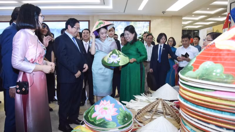 Thủ tướng Thái Lan Paetongtarn Shinawatra nghe giới thiệu về sản phẩm nón lá truyền thống của Việt Nam. (Ảnh: TRẦN HẢI)