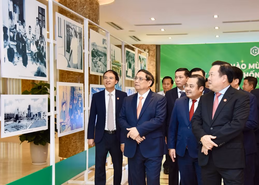 Thủ tướng Phạm Minh Chính nghe giới thiệu về triển lãm ảnh về quá trình xây dựng và phát triển ngành Hóa chất Việt Nam. (Ảnh: Trần Hải)