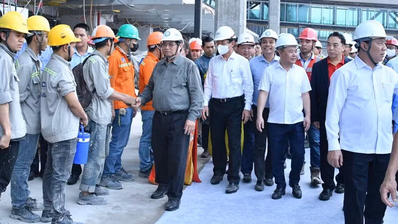 Thủ tướng Phạm Minh Chính thăm hỏi đội ngũ kỹ sư, công nhân đang thi công trên công trường. (Ảnh: THANH GIANG)