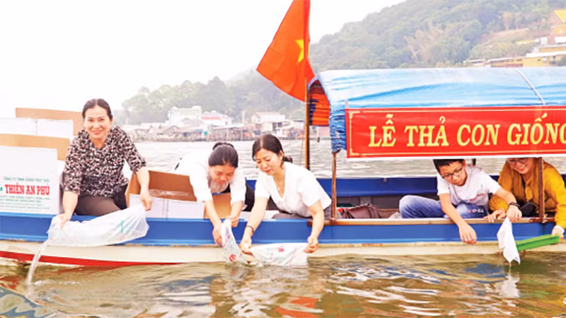 Đại diện ngành chức năng, doanh nghiệp thả con giống tôm, cua, cá xuống đầm Đông Hồ.