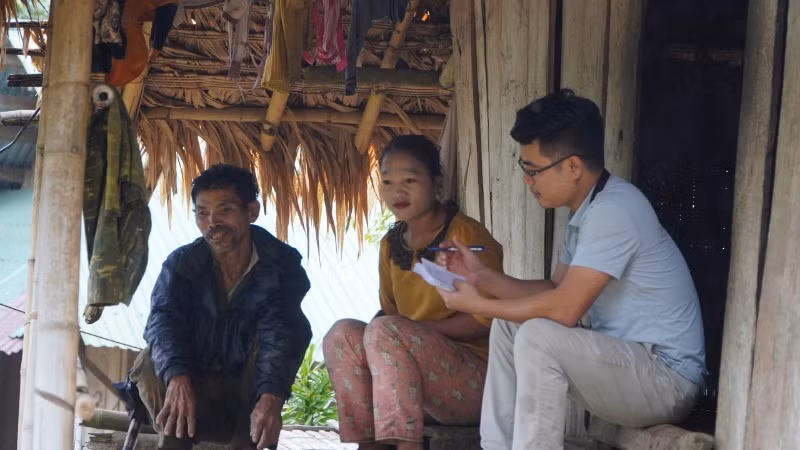 Phóng viên Báo Nhân Dân trao đổi thông tin với một hộ gia đình người đồng bào Khơ Mú. Hạ tầng thiếu thốn, đời sống người dân vùng lòng hồ Thủy điện Bản Vẽ đang gặp rất nhiều khó khăn.