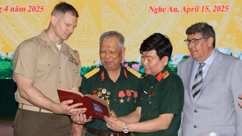 Cựu chiến binh Lê Đức Thuận (thứ 2, từ trái sang) xúc động khi nhận lại cuốn sổ ghi chép của mình.