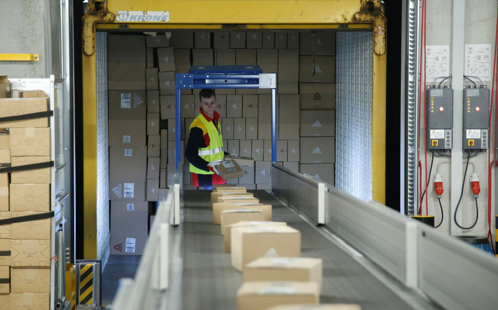 Một nhân viên đặt các bưu kiện lên băng chuyền tại trung tâm bưu kiện mới của DHL/Deutsche Post ở Bochum, Đức, ngày 18/11/2019. (Ảnh: REUTERS)
