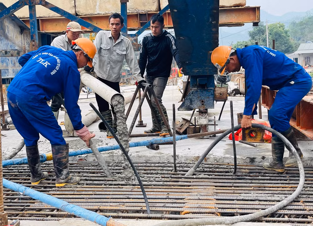 Các công nhân đang đổ bê tông hợp long cầu Tô Mậu.