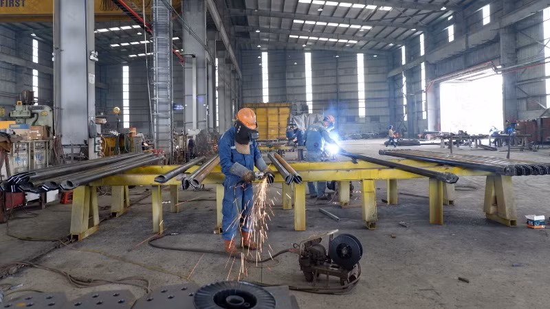 Gấp rút sản xuất cột thép để bàn giao trên công trường. (Ảnh: LÊ CHI)