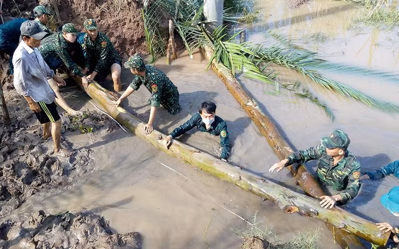 Cán bộ, đoàn viên Chi đoàn Đồn Biên phòng An Thạnh Ba, Bộ đội Biên phòng tỉnh Sóc Trăng giúp dân khắc phục hậu quả do thiên tai gây ra.