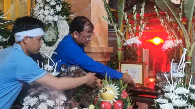 Bí thư Tỉnh đoàn Thái Bình Thiệu Minh Quỳnh đặt Huy hiệu "Tuổi trẻ dũng cảm" trước di ảnh Trung úy công an Đỗ Văn Tú. (Ảnh: Tỉnh đoàn Thái Bình cung cấp)