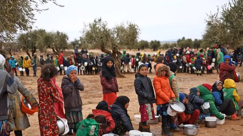 Trẻ em Syria xếp hàng chờ nhận thức ăn cứu trợ tại trại tị nạn ở Yazi Bagh, tỉnh Aleppo. (Ảnh: AFP/TTXVN)