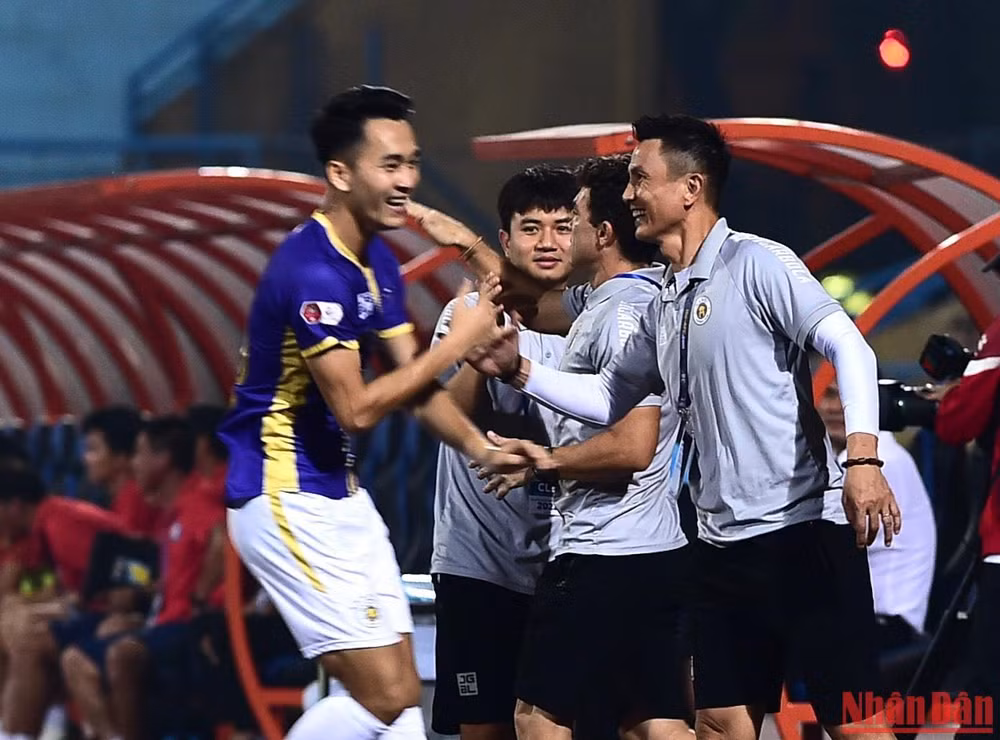 Lê Xuân Tú chia vui cùng ban huấn luyện sau khi ghi bàn thắng thứ 3 cho đội Hà Nội FC.