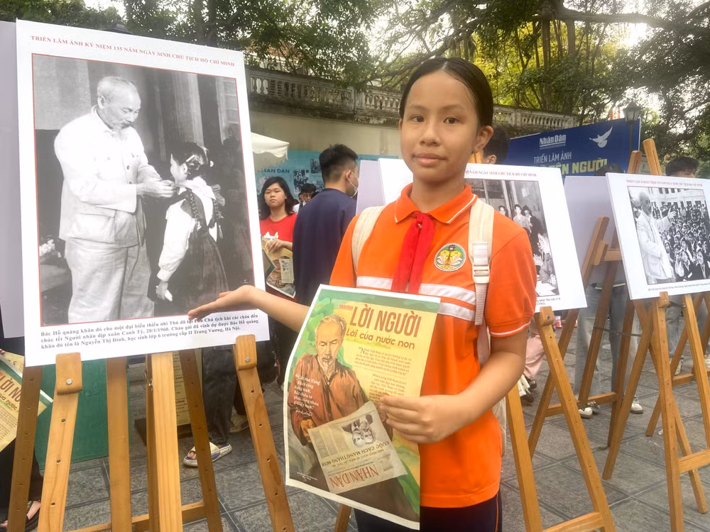 Phạm Phương Anh bên bức ảnh Chủ tịch Hồ Chí Minh đeo khăn quàng đỏ cho bà Nguyễn Thị Định.