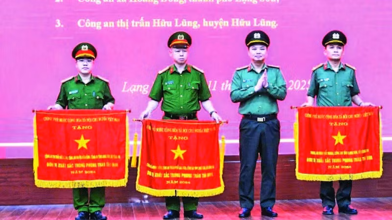 Giám đốc Công an tỉnh trao Cờ thi đua của Chính phủ cho ba tập thể đã có thành tích xuất sắc. (Ảnh VIỆT DŨNG)