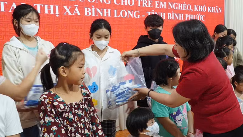 Hội Chữ thập đỏ tỉnh Bình Phước trao sữa tặng trẻ em nghèo, có hoàn cảnh khó khăn. (Ảnh KIÊN MINH)