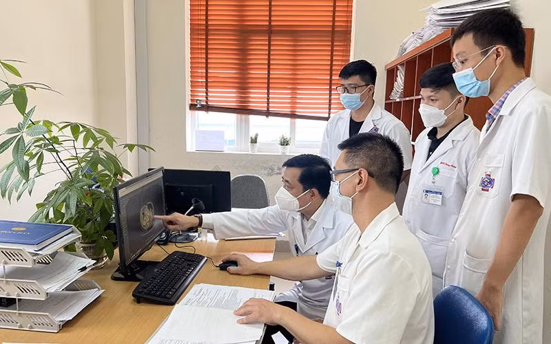 Các bác sĩ Bệnh viện K hội chẩn, đánh giá trước khi thực hiện ca phẫu thuật điều trị ung thư cho người bệnh. (Ảnh THÁI HÀ)