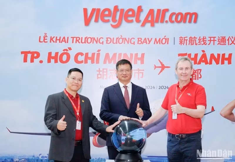 Tổng Lãnh sự Trung Quốc tại Thành phố Hồ Chí Minh Ngụy Hoa Tường (giữa) - Phó Tổng giám đốc vận hành Vietjet Micheal Hickey (bên phải ngoài cùng) - Phó Tổng giám đốc thương mại Vietjet Nguyễn Bác Toán (bên trái ngoài cùng) thực hiện nghi thức khai trương đường bay Thành phố Hồ Chí Minh-Thành Đô.