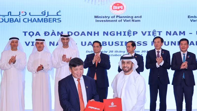 Đại diện lãnh đạo Vietjet (trái) và Emirates (phải) trao thỏa thuận hợp tác mở rộng kết nối quốc tế trước sự chứng kiến của Thủ tướng Phạm Minh Chính (giữa) tại Dubai, UAE.