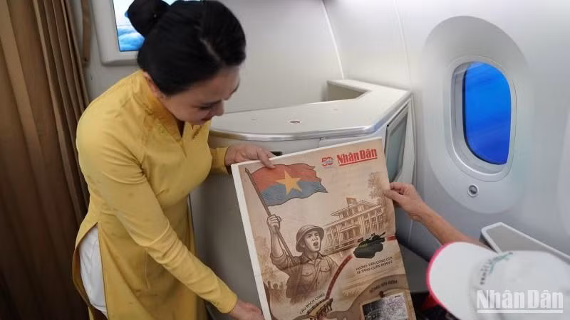 Hành khách trên chuyến bay bất ngờ nhận được món quà ý nghĩa từ Vietnam Airlines - tờ phụ san đặc biệt của báo Nhân Dân về sự kiện 30/4.