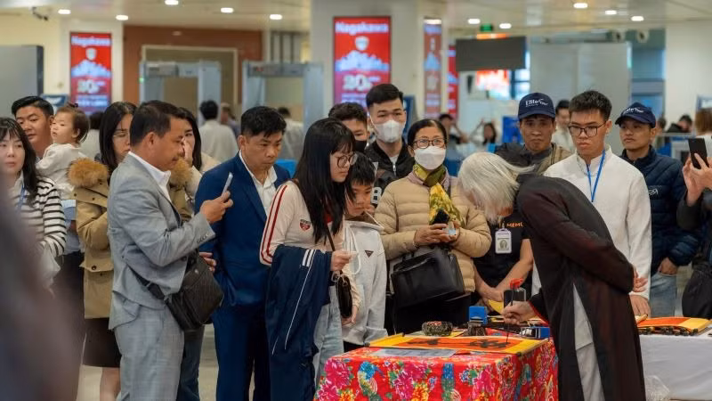 Thầy đồ viết và tặng chữ thư pháp như lời chúc may mắn đầu năm.