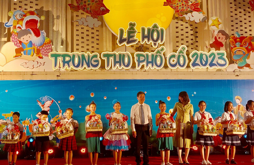 Lãnh đạo Uỷ ban nhân dân quận Hoàn Kiếm trao quà cho các em học sinh.