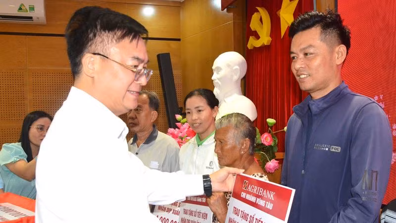 Ông Hoàng Vũ Thảnh, Chủ tịch Ủy ban nhân dân thành phố Vũng Tàu trao sổ tiết kiệm cho người dân khó khăn.