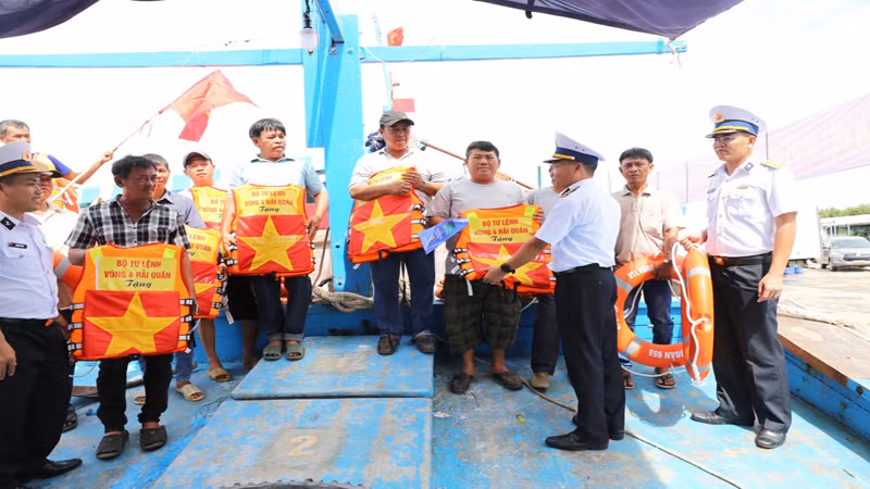 Trao tặng cờ Tổ quốc cho ngư dân.