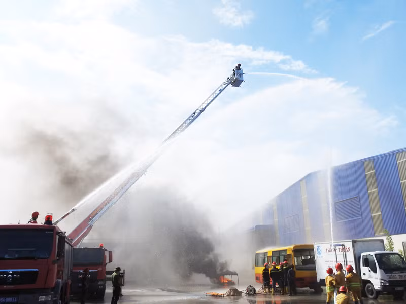 Các lực lượng được huy động tham gia chữa cháy tại buổi diễn tập dùng phương tiện chuyên dùng hiện đại cùng phối hợp phun nước để dập tắt đám cháy. (Ảnh: NGUYỄN TRUNG)