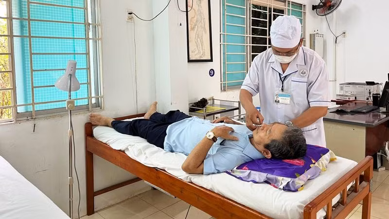 Y sĩ Nguyễn Hữu Đức điều trị cho bệnh nhân (Ảnh: NGUYỄN TRUNG)