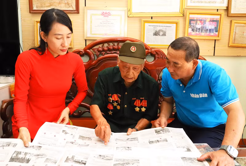 Cụ Nguyễn Ngọc Điệp chỉ tay vào ấn phẩm giới thiệu và kể lại diễn biến mà cụ đã cùng với đồng đội tấn công hỏa lực vào sào huyệt quân địch, góp phần vào chiến thắng của chiến dịch