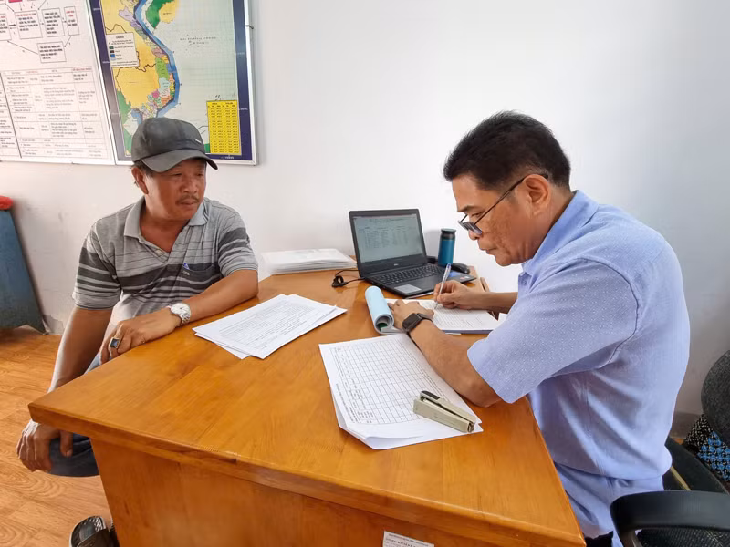 Cán bộ Ban Quản lý cảng Ninh Chử, xã Tri Hải, huyện Ninh Hải (Ninh Thuận), kiểm tra hồ sơ, nhật ký hoạt động khai thác thủy sản của ngư dân tại địa phương đã hết hạn để cấp lại giấy phép hoạt động, bảo đảm các thủ tục pháp lý cho ngư dân vươn khơi (Ảnh: NGUYỄN TRUNG)