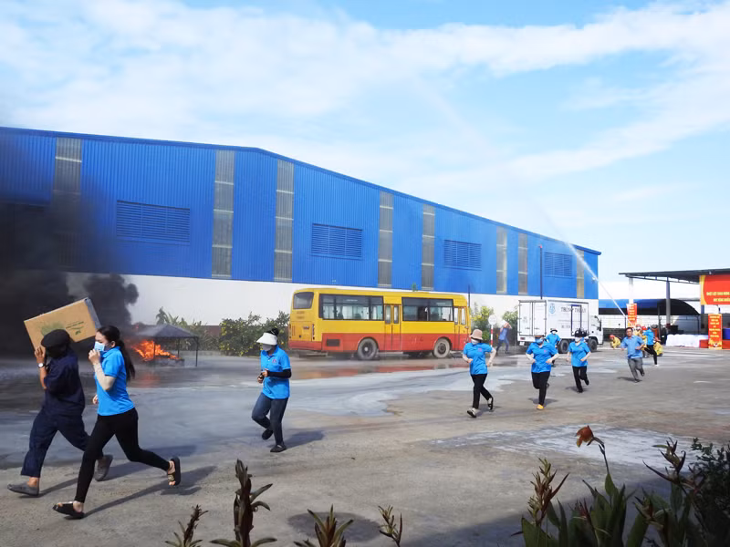 Lực lượng cứu nạn, cứu hộ vừa di chuyển tài sản vừa hướng dẫn công nhân trong nhà xưởng vượt ra ngoài bằng lối thoát hiểm an toàn (Ảnh: NGUYỄN TRUNG)