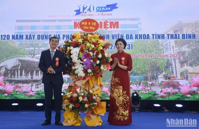 Giáo sư, Tiến sĩ Trần Văn Thuấn, Thứ trưởng Y tế tặng hoa chúc mừng.