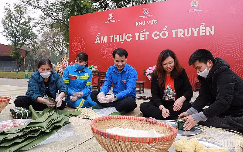 Đại diện Ban Tổ chức và người lao động cùng gói bánh chưng tại khu vực ẩm thực Tết cổ truyền trong khuôn khổ Ngày hội “Cùng nhau làm nên Tết” năm 2023.