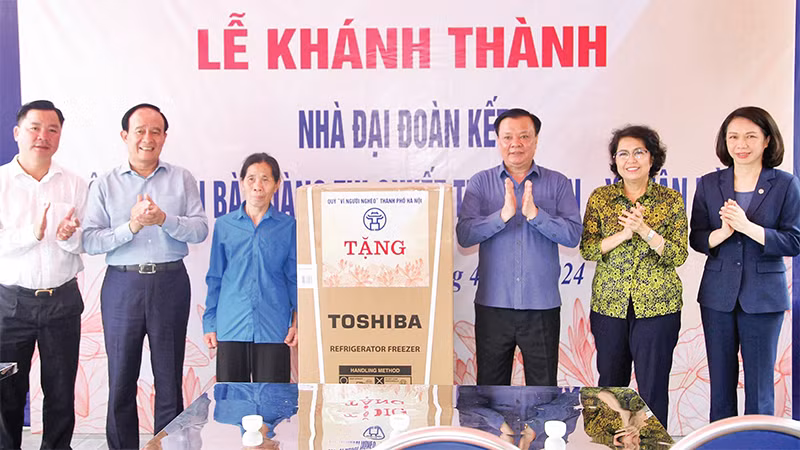 Bí thư Thành ủy Ðinh Tiến Dũng cùng các đồng chí lãnh đạo trao quà mừng nhà mới tặng gia đình bà Hoàng Thị Quyết. (Ảnh Thành Nguyễn) 