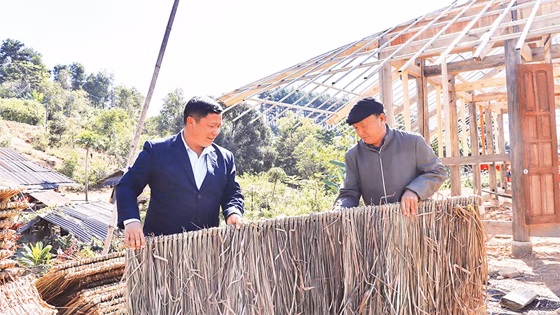 Già làng Cư Chừ Tú (bên phải) hướng dẫn người dân bản Tìa Ló B, xã Nong U, huyện Ðiện Biên Ðông, tỉnh Ðiện Biên làm nhà ở. 