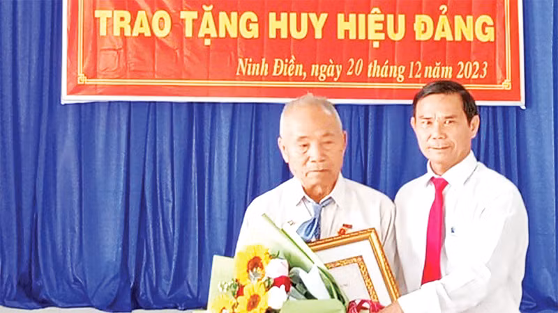 Ðồng chí Thân Văn Nhân, Phó Bí thư Thường trực Huyện ủy Châu Thành (Tây Ninh) trao Huy hiệu 55 năm tuổi đảng tặng đảng viên Lâm Văn Búp. 