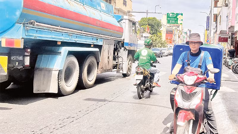 Một người chở hàng hóa đi ngược chiều trên đường Hai Bà Trưng, Quận 1. 
