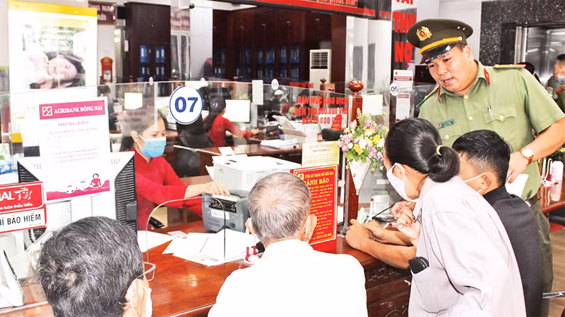 Công an thành phố Biên Hòa tuyên truyền về phương thức, thủ đoạn của tội phạm cho khách hàng đến giao dịch tại Agribank chi nhánh tỉnh Ðồng Nai. (Ảnh tư liệu) 