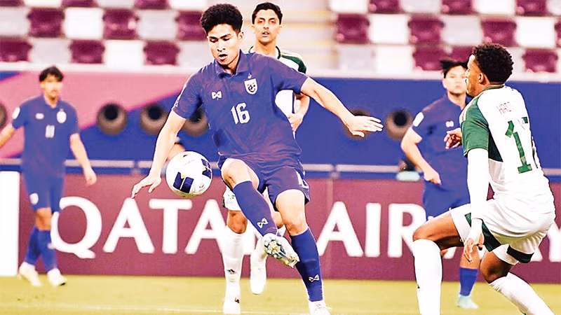 Pha tranh bóng trong trận U23 Thái Lan (áo xanh) thua U23 Saudi Arabia 0-5. 