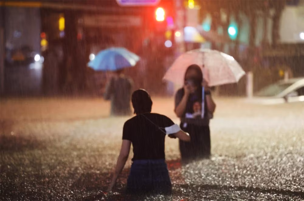 Lội nước trên đường phố tại quận Gangnam. (Ảnh: Yonhap)