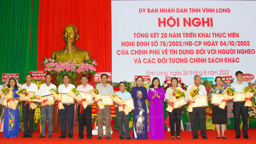 Lãnh đạo UBND tỉnh Vĩnh Long tặng Bằng khen cho những tập thể và cá nhân đã có thành tích trong triển khai, thực hiện vốn vay ưu đãi đối với hộ nghèo và các đối tượng chính sách. (Ảnh: BÁ DŨNG)