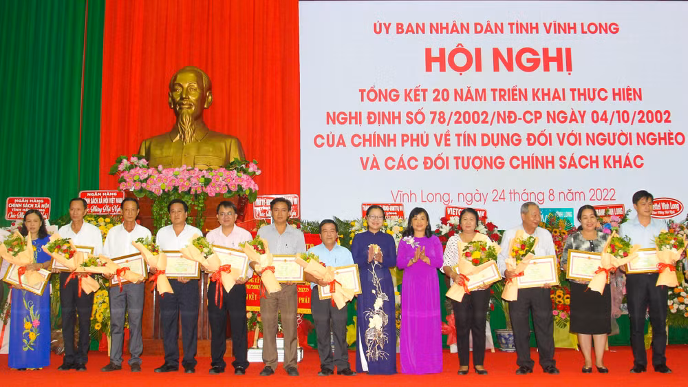 Lãnh đạo UBND tỉnh Vĩnh Long tặng Bằng khen cho những tập thể và cá nhân đã có thành tích trong triển khai, thực hiện vốn vay ưu đãi đối với hộ nghèo và các đối tượng chính sách. (Ảnh: BÁ DŨNG)