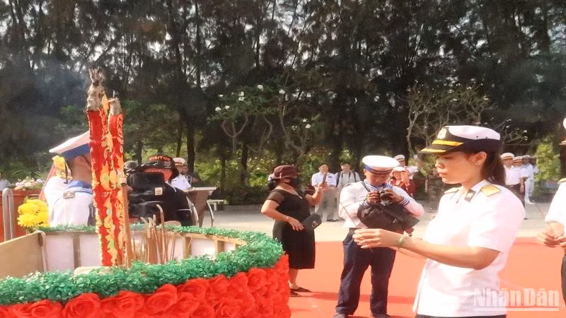 Đại úy Trần Thị Thủy, con gái của Anh hùng liệt sĩ Trần Văn Phương, người hy sinh trong trận hải chiến ngày 14/3/1988, dâng hương tưởng niệm các anh hùng liệt sĩ. (Ảnh: PHONG NGUYÊN)