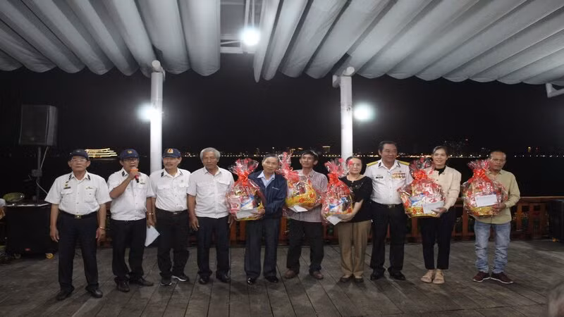 Thương binh Nguyễn Văn Dũng (thứ ba từ phải sang) tặng quà gia đình liệt sĩ Trường Sa. (Ảnh: VĂN TÀI)