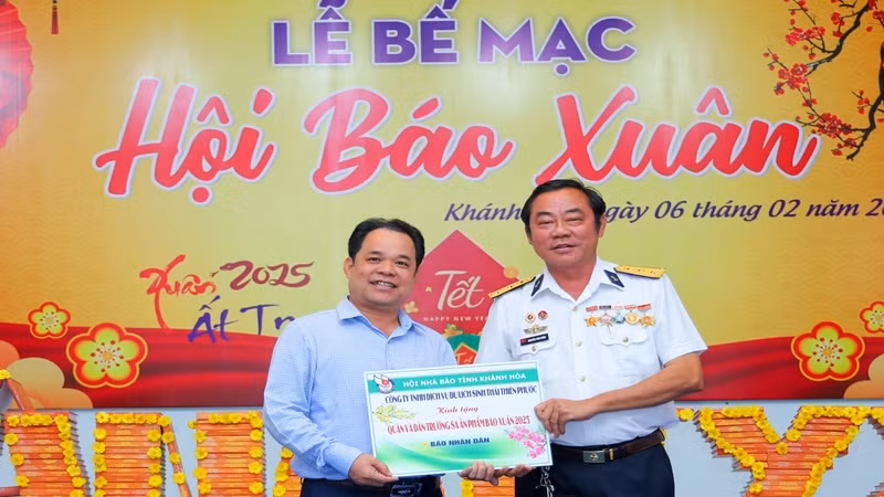 Cựu binh Trường Sa Nguyễn Văn Dũng (bên phải) tặng tượng trưng ấn phẩm Nhân Dân Xuân Ất Tỵ 2025 đến quân, dân huyện đảo Trường Sa. (Ảnh: PHONG NGUYÊN) 