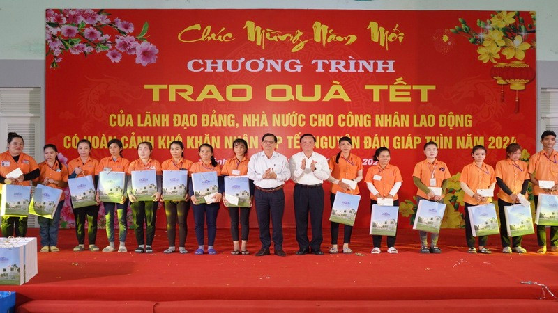 Phó Chủ tịch Quốc hội Nguyễn Khắc Định và Chủ tịch Ủy ban nhân dân tỉnh Khánh Hòa trao quà Tết tặng công nhân có hoàn cảnh khó khăn tại Khu Công nghiệp Suối Dầu. (Ảnh: VÕ TOÀN) 