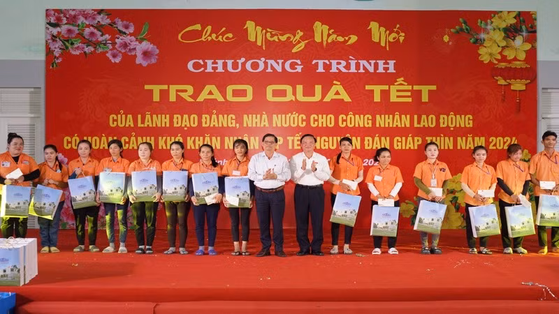 Phó Chủ tịch Quốc hội Nguyễn Khắc Định và Chủ tịch Ủy ban nhân dân tỉnh Khánh Hòa trao quà Tết tặng công nhân có hoàn cảnh khó khăn tại Khu Công nghiệp Suối Dầu. (Ảnh: VÕ TOÀN) 